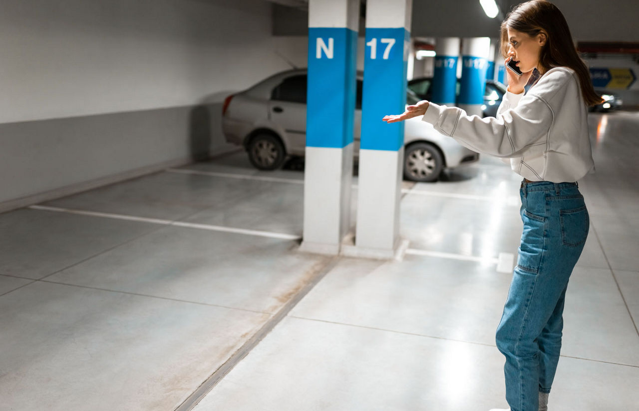 Girl after shopping discovered the loss of her automobile. Angry woman talking about missing car on phone. Vehicle theft concept