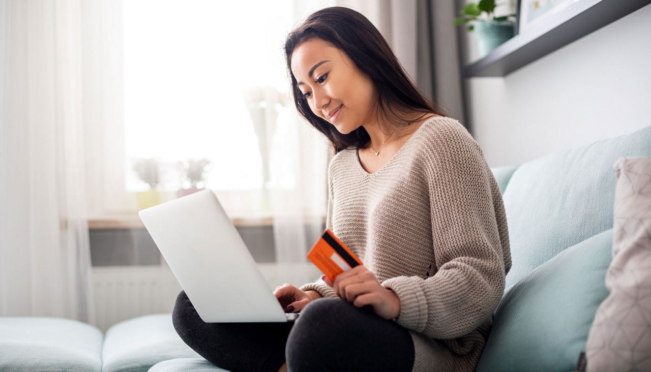 Asian girl making online payment using laptop for shopping at home