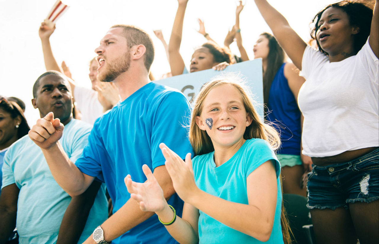 young girl with dad at a sports game