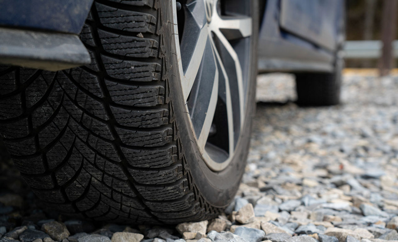 Close up of car wheel on a stone road