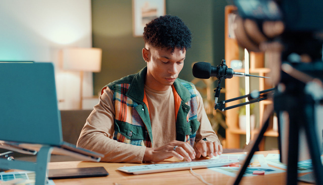 Man, influencer and typing in recording studio for audio podcast or content creation at home