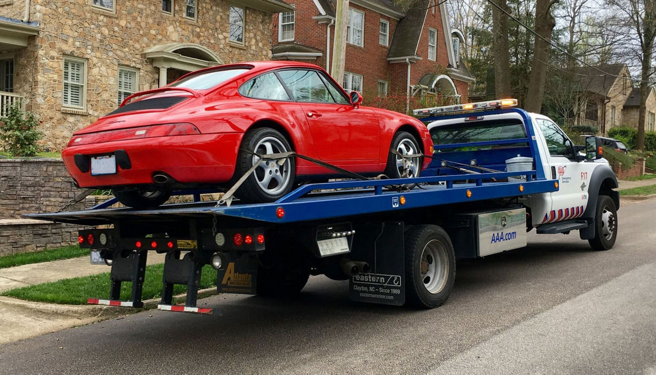 Red sport car on a AAA flatbed tow truck