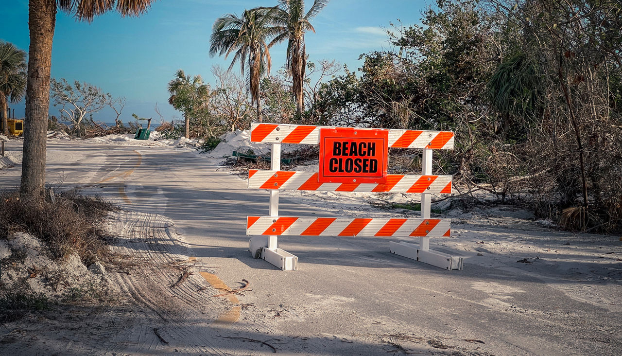 Beach closed road barricade sign after a storm disaster