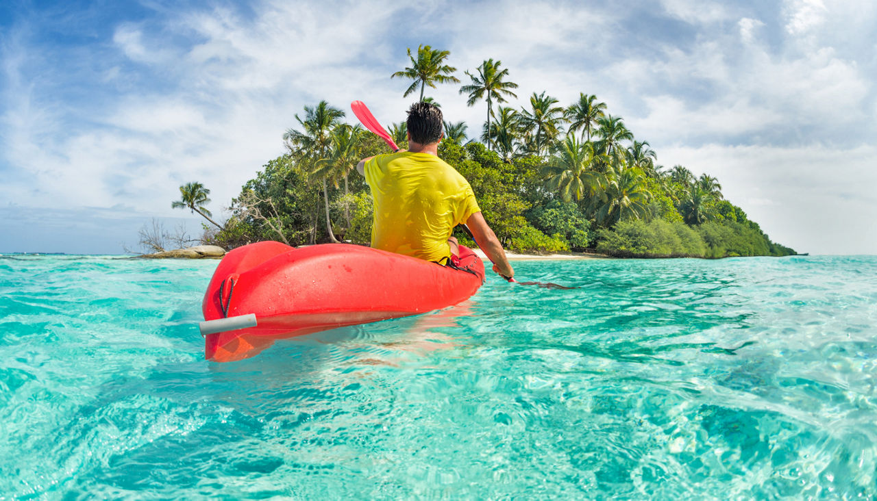 Man kayaking in the Caribbean towards an island