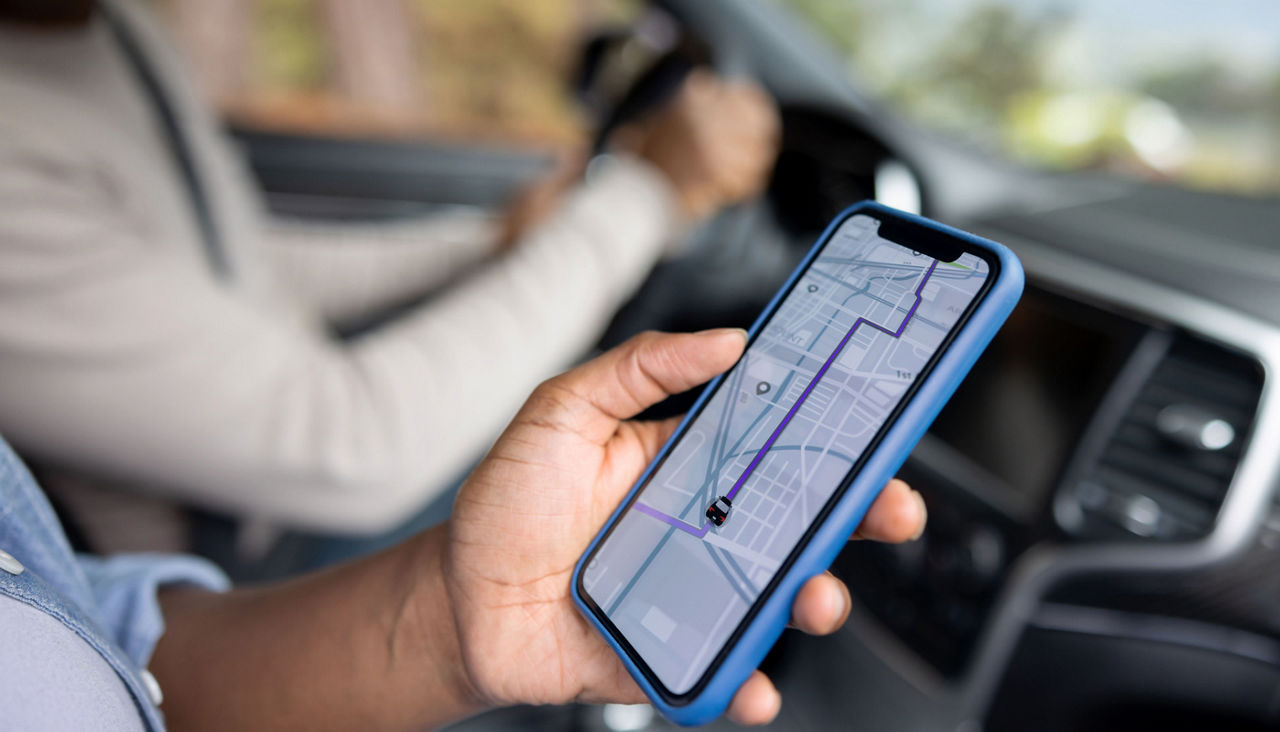 Close-up on a couple using the GPS on a cell phone while driving a car