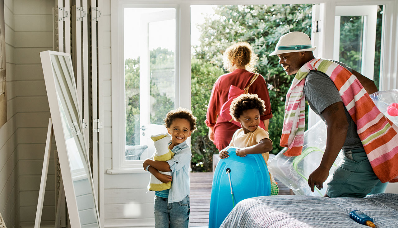 Father, mother and two sons about to leave room for a day at the beach