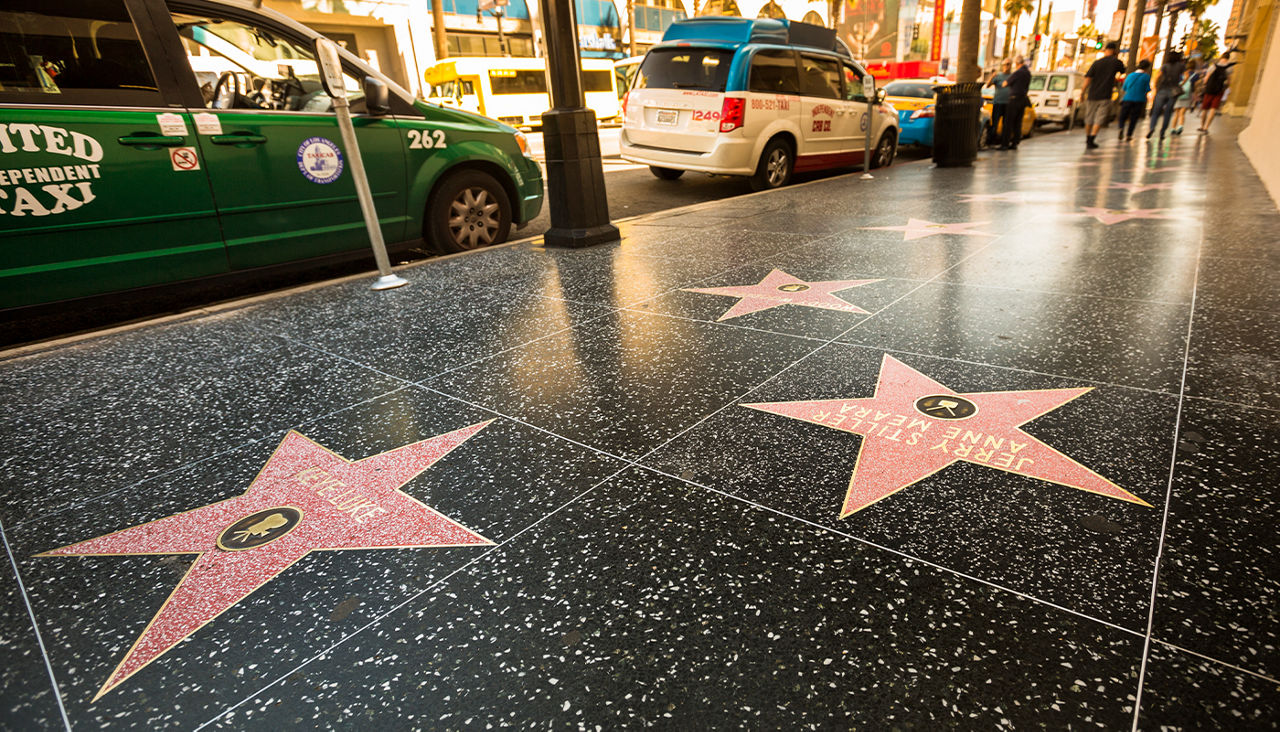 A stretch of the Hollywood Walk of Fame stars at night.