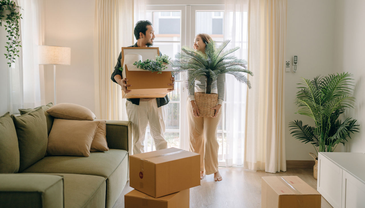 Couple moving boxes into new house