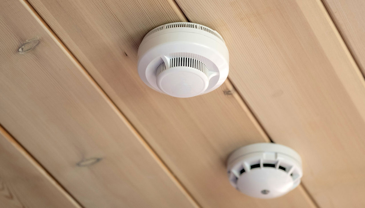 Smoke and carbon monoxide detectors on a wood ceiling