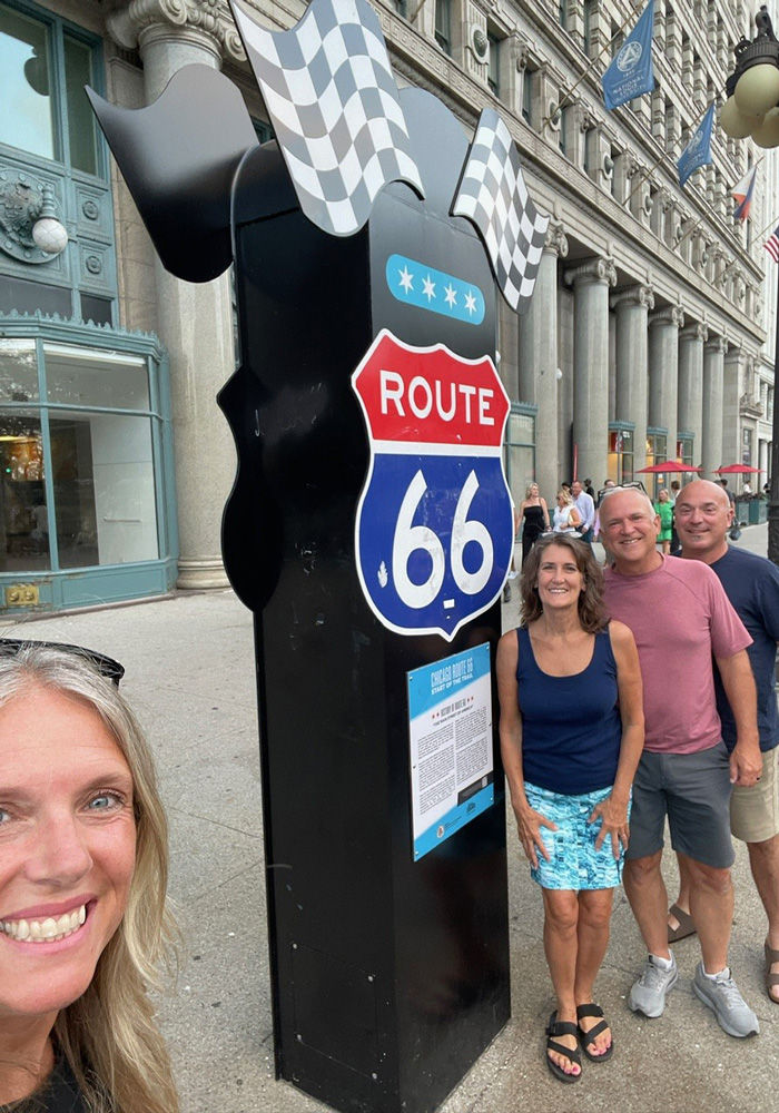 John Ribbing and group posing in front of Route 66 sign in Chicago