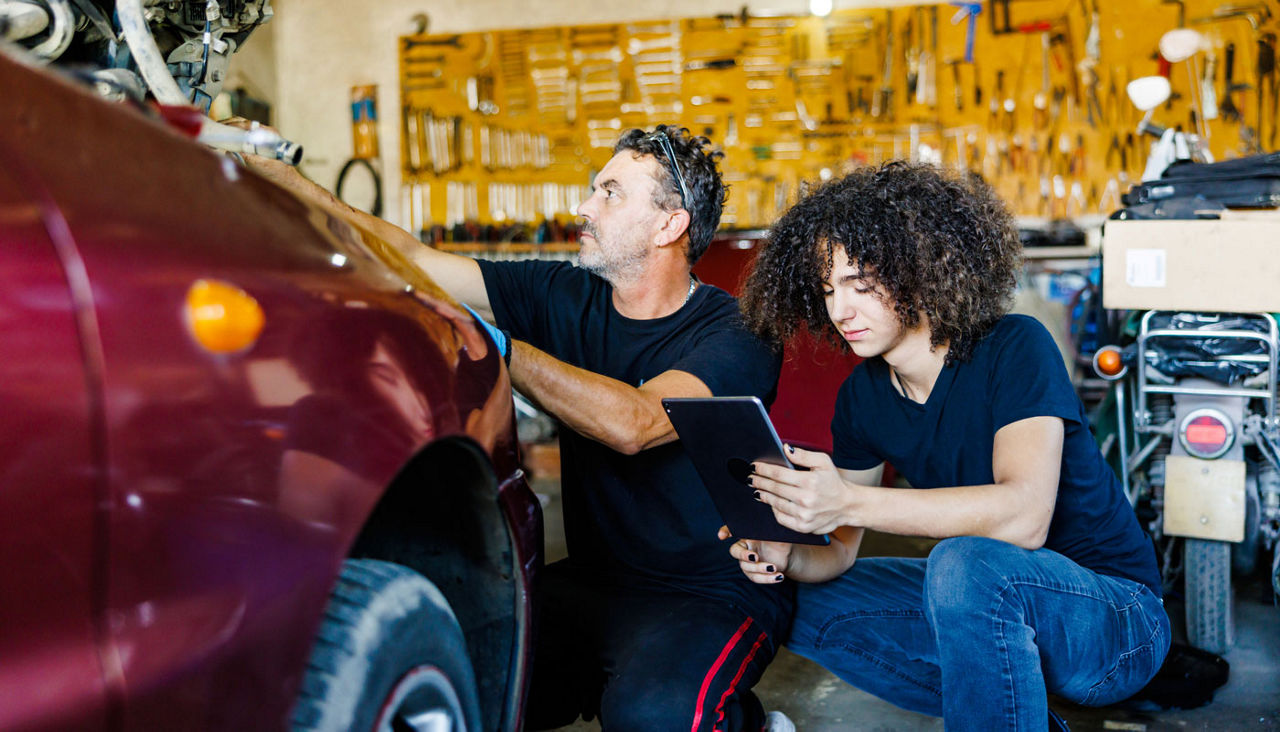 Teenager learning car mechanic with internet help