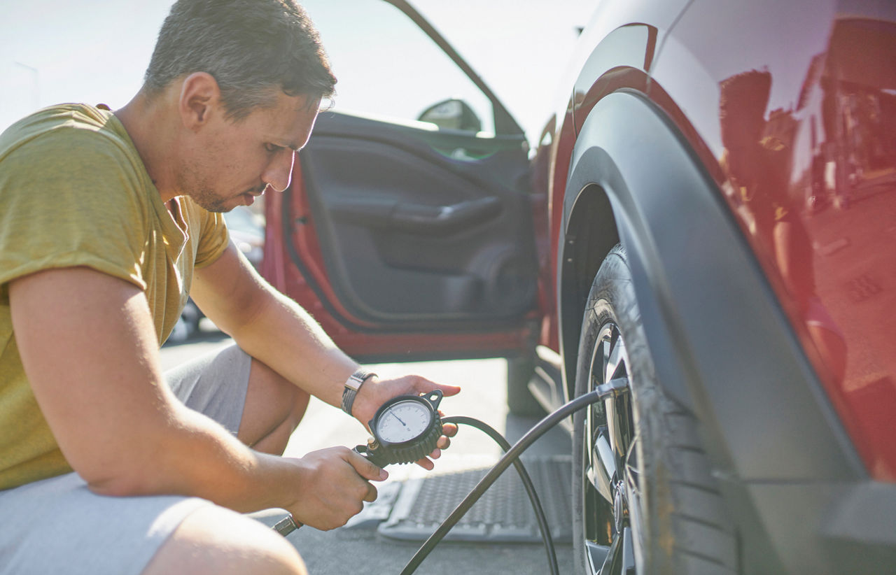 Man checking the tire pressure with a tire pressure gauge