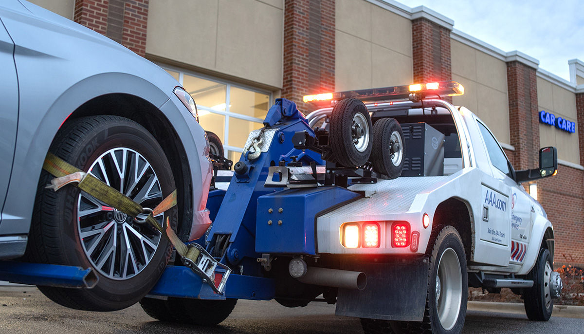 Tow truck towing a car to a car care facility