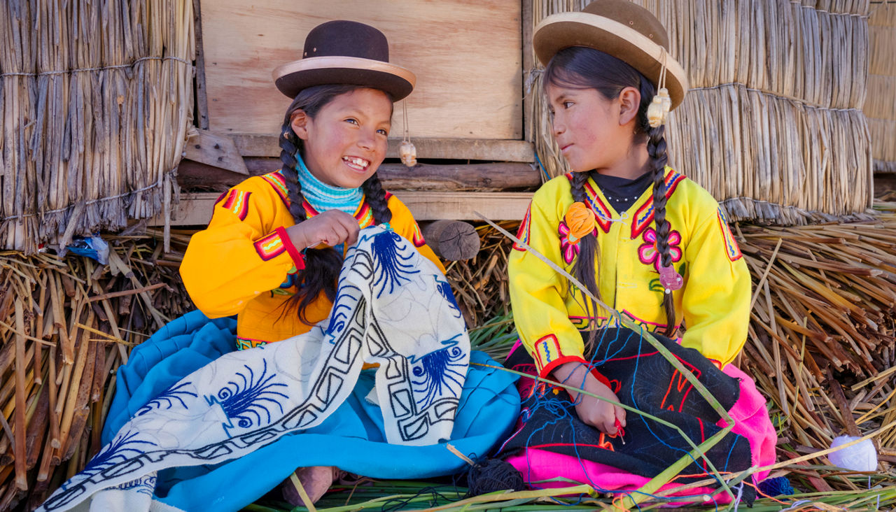 Peruvian young girls embroidering on Uros floating island, Lake Titicaca, Peru