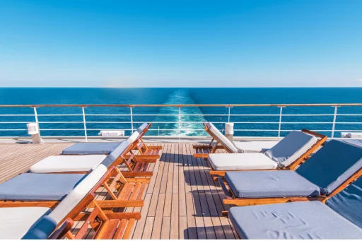 Cruise ship lounge chairs on deck with view of the water