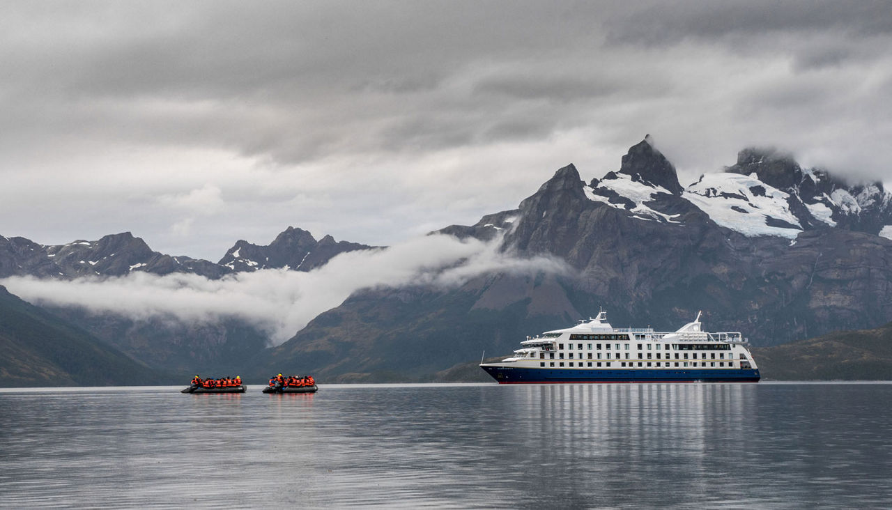 Two boats approaching a Cruise ship in the Patagonian Fiords