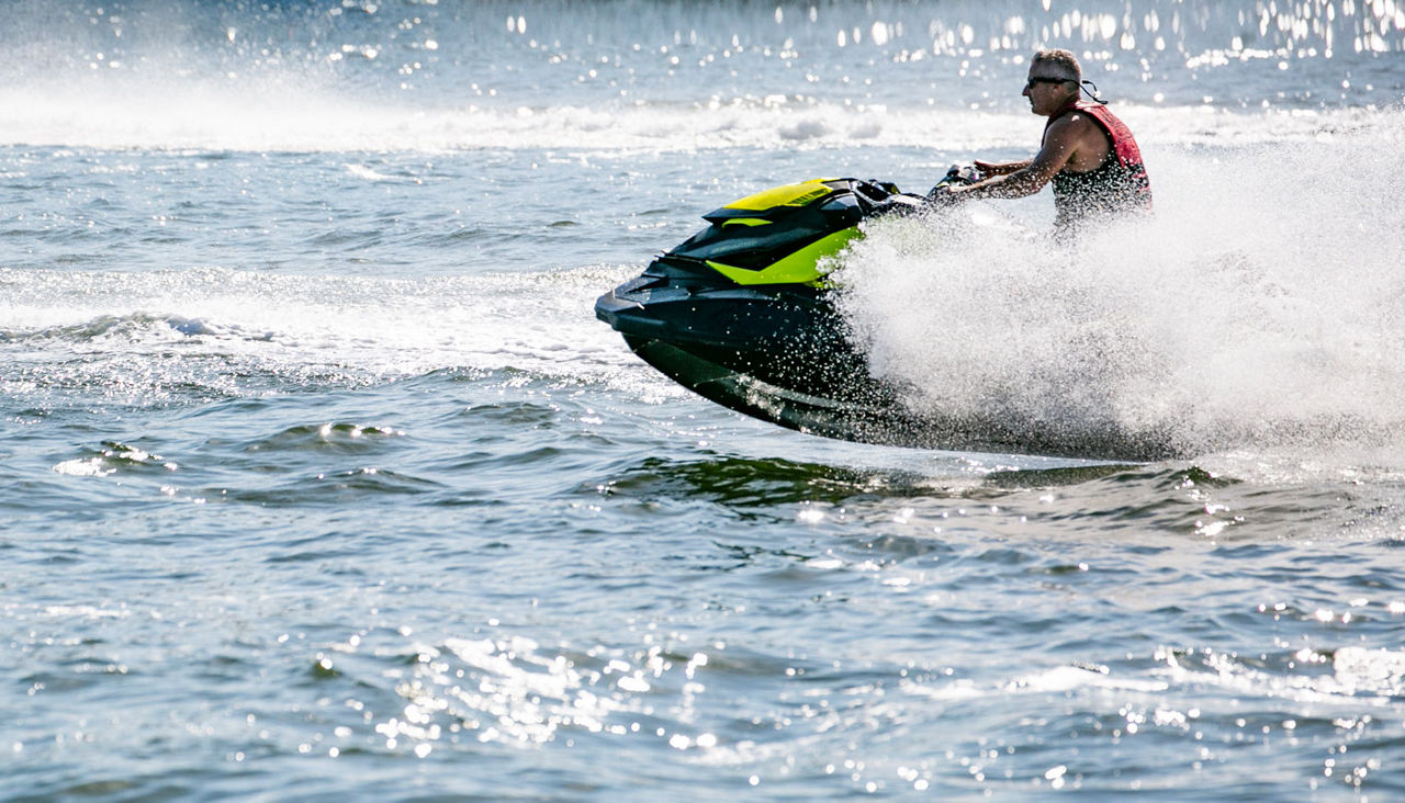 man riding wave runner on the water