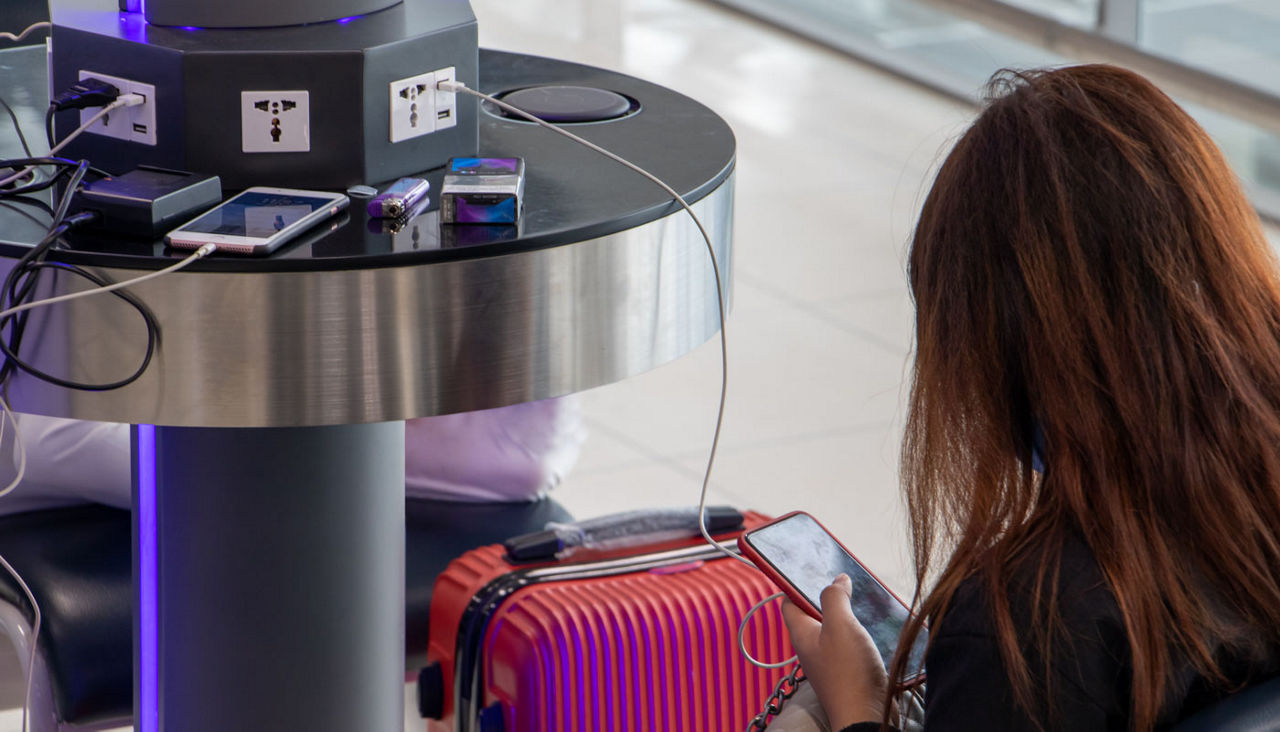 Recharging mobile phones from free charge station at the airport.