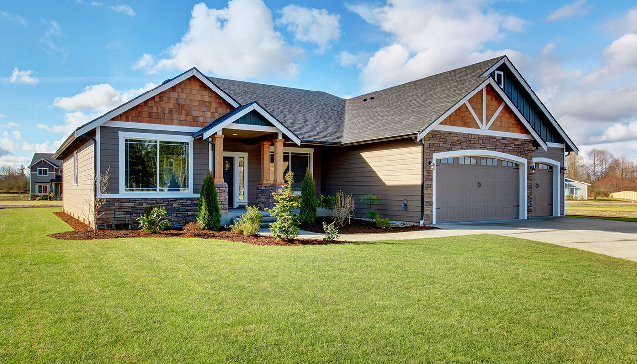 Large modern house with stone and walkway.