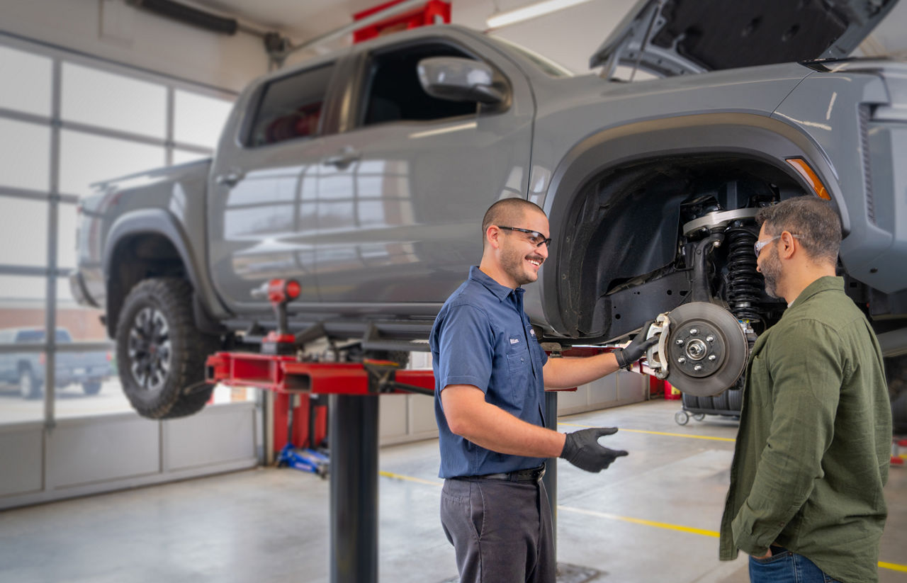 Service tech discussing brakes with the customer in the service bay