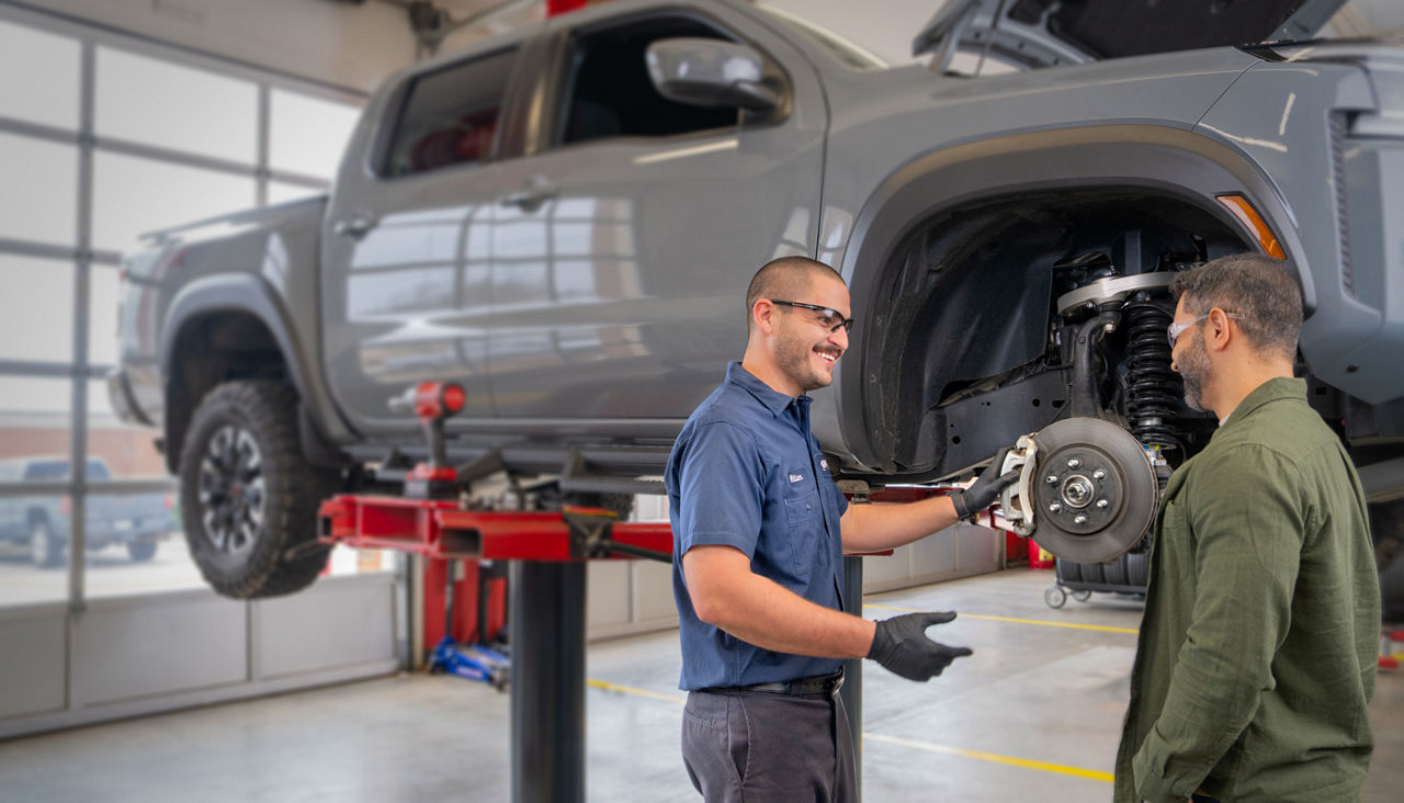 AAA Car Care technician talking with customer about repairs