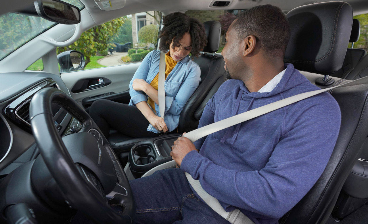 Couple is show buckling up in a vehicle