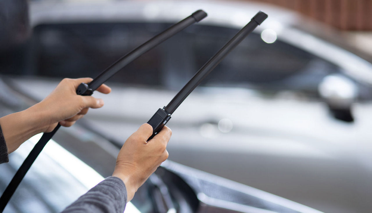 Technician replacing windshield wiper blades