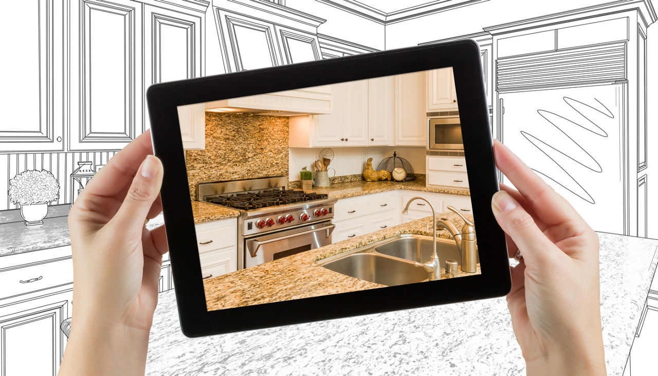 Female hands holding computer tablet with kitchen on screen & drawing behind