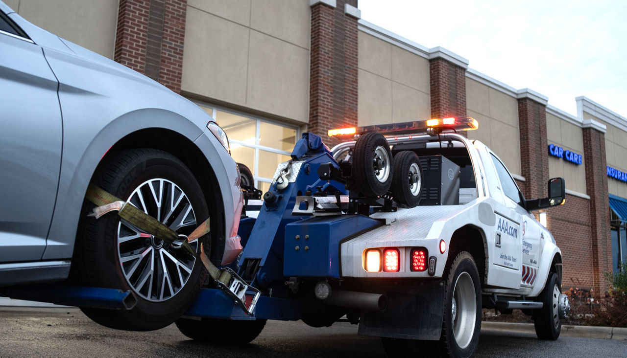 AAA tow truck towing a car into a Car Care Center