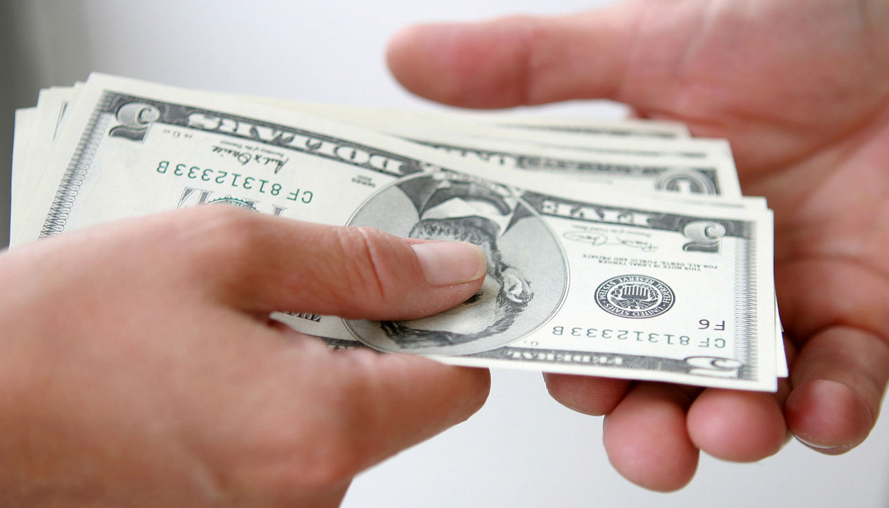 Two people exchanging money, close up of hands