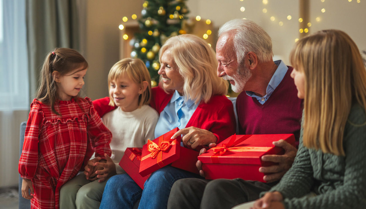 Grandparents and grandchildren exchanging gifts during christmas celebration