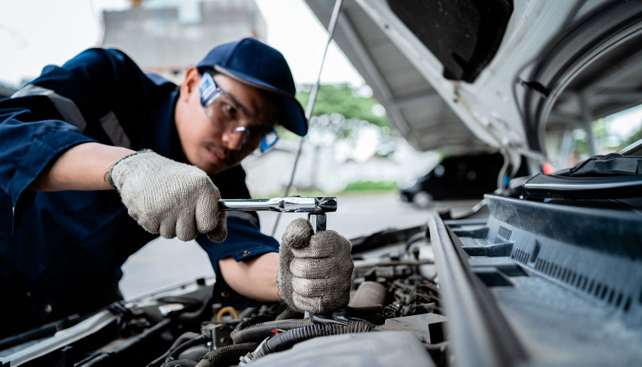 A mechanic is working on a car engine