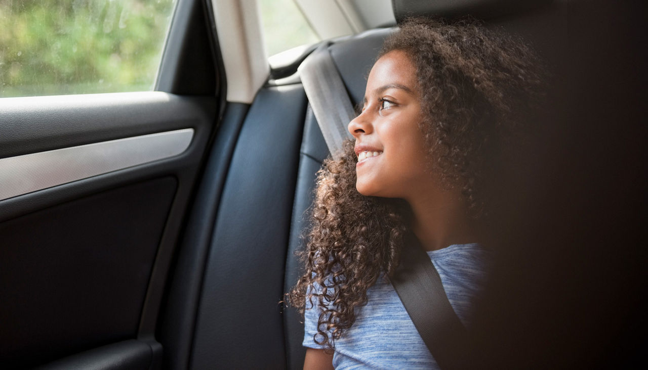 Smiling girl in car looking out window