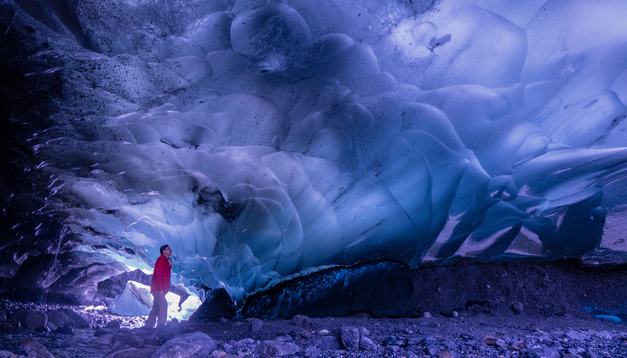 Man inside the Mendenhall Ice Cave in Alaska