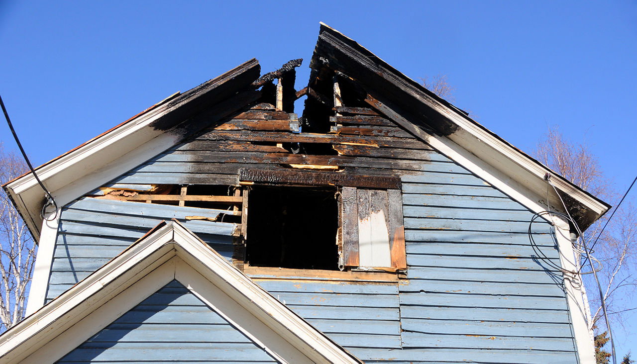 A house roof after a fire burnt the top of it.