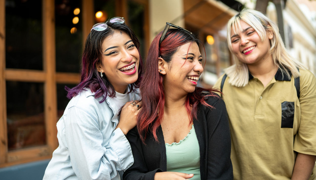 Group of young girl friends laughing and posing for a photo outside