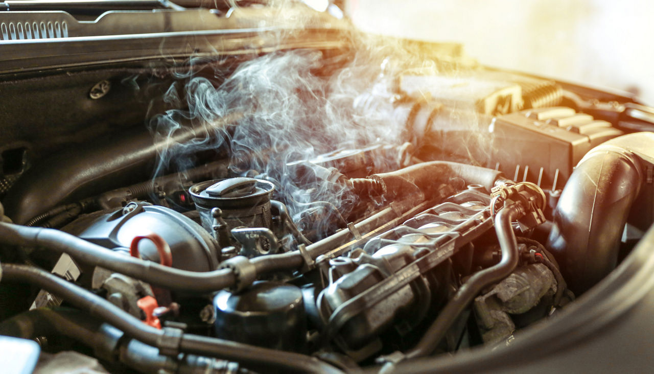 Close up of car engine overheating and smoking