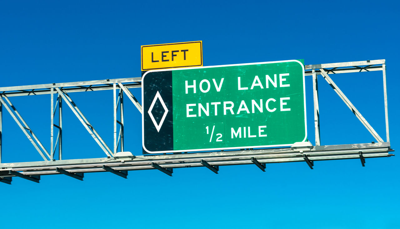 A green highway sign reading, “LEFT: HOV LANE ENTRACE ½ MILE.”