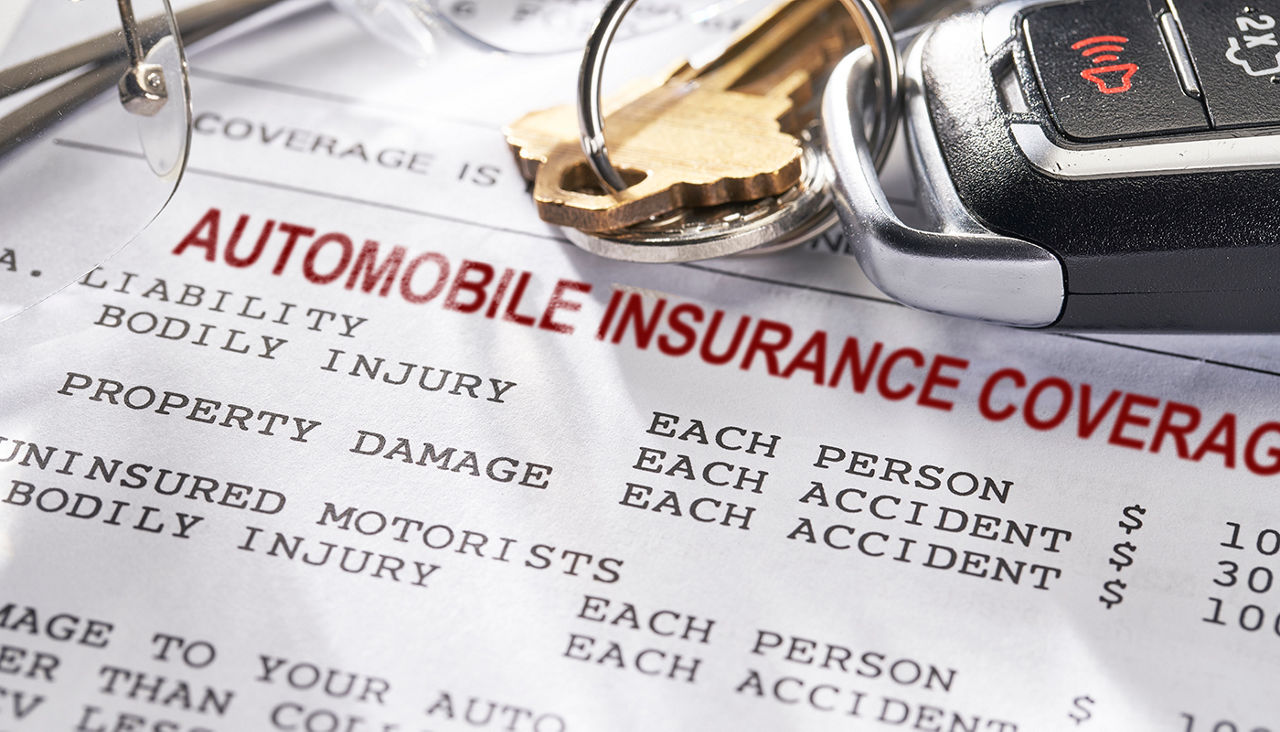 Auto Insurance policy with keys and glasses