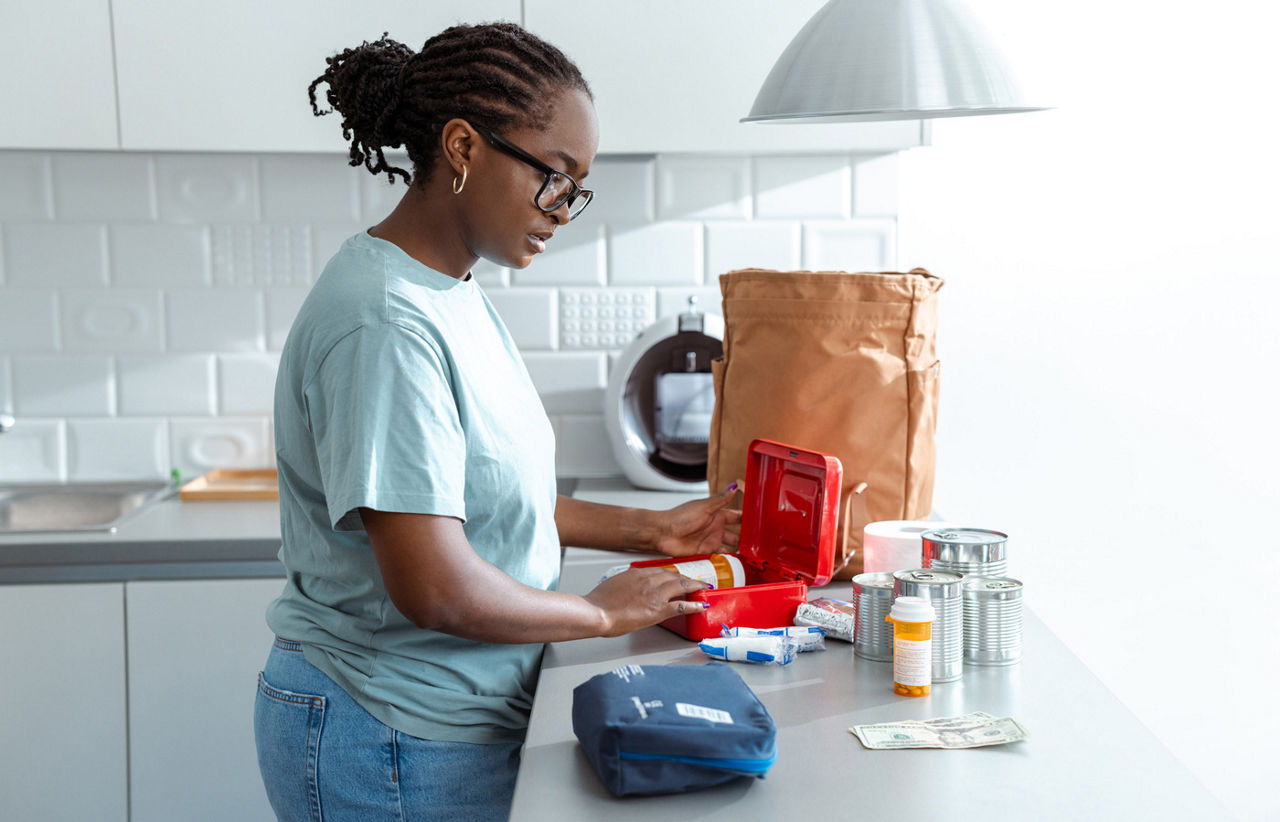 Woman preparing medications and supplies for hurricane evacuation or emergency kit