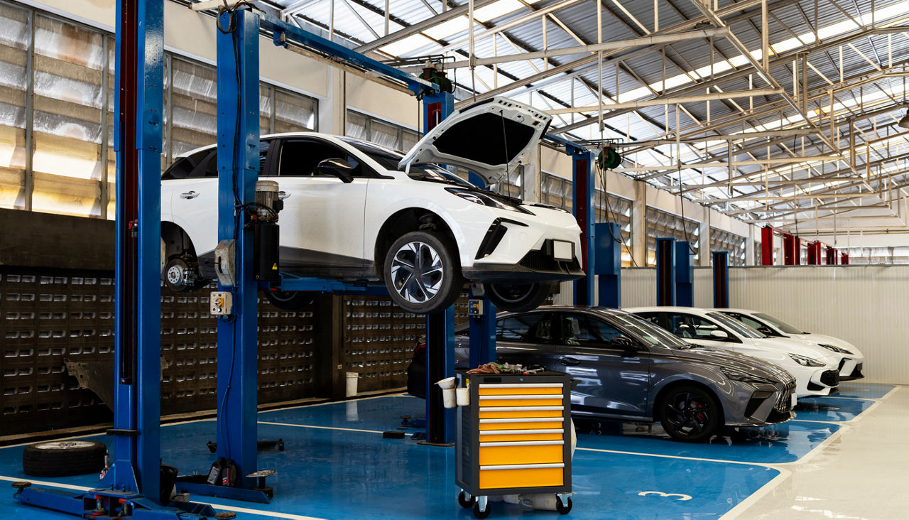 Electric car on hydraulic lift in modern auto repair workshop