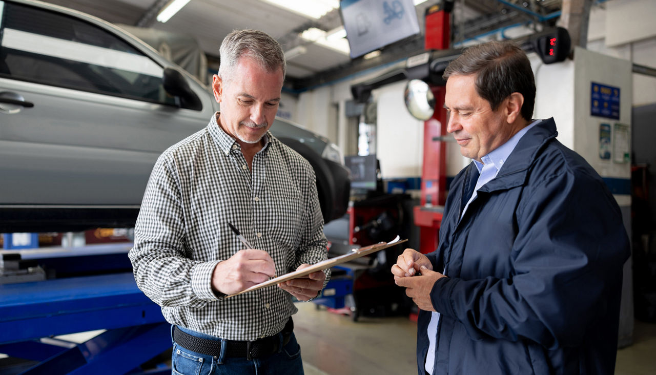 Customer leaving his car at an auto repair shop and signing a form