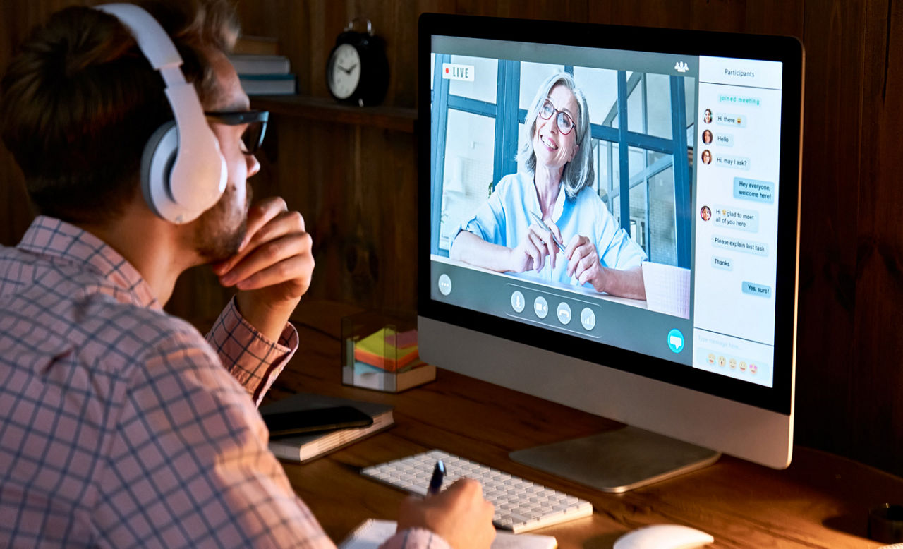 Male wearing headphones taking online course training, watching webinar, or virtual training