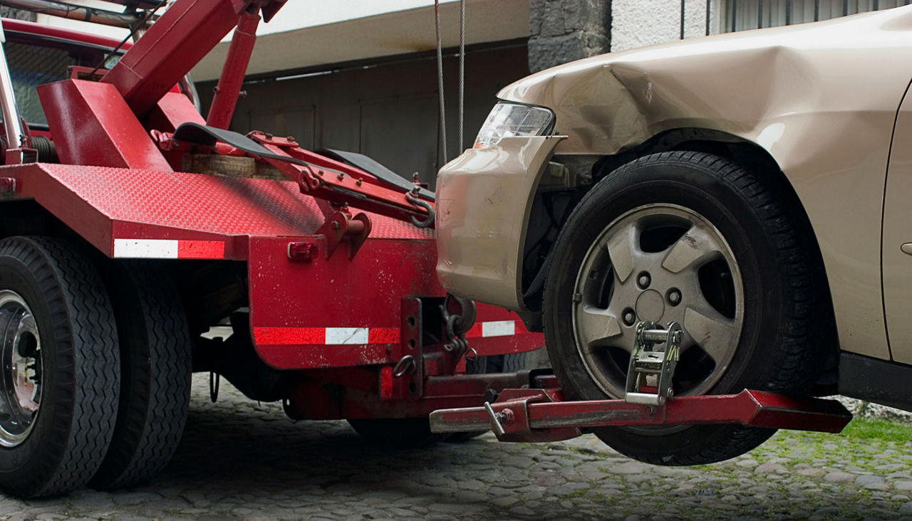 Wheel lift tow truck towing a car