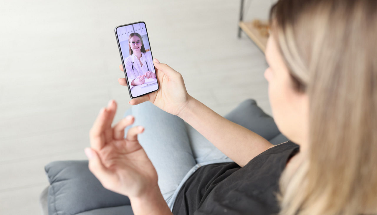 Woman is on a Remote medical consultation with a doctor on her phone