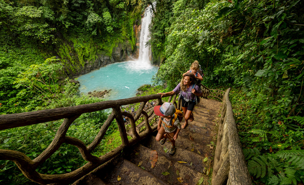 family hiking at Rio Celeste waterfall in Costa Rica