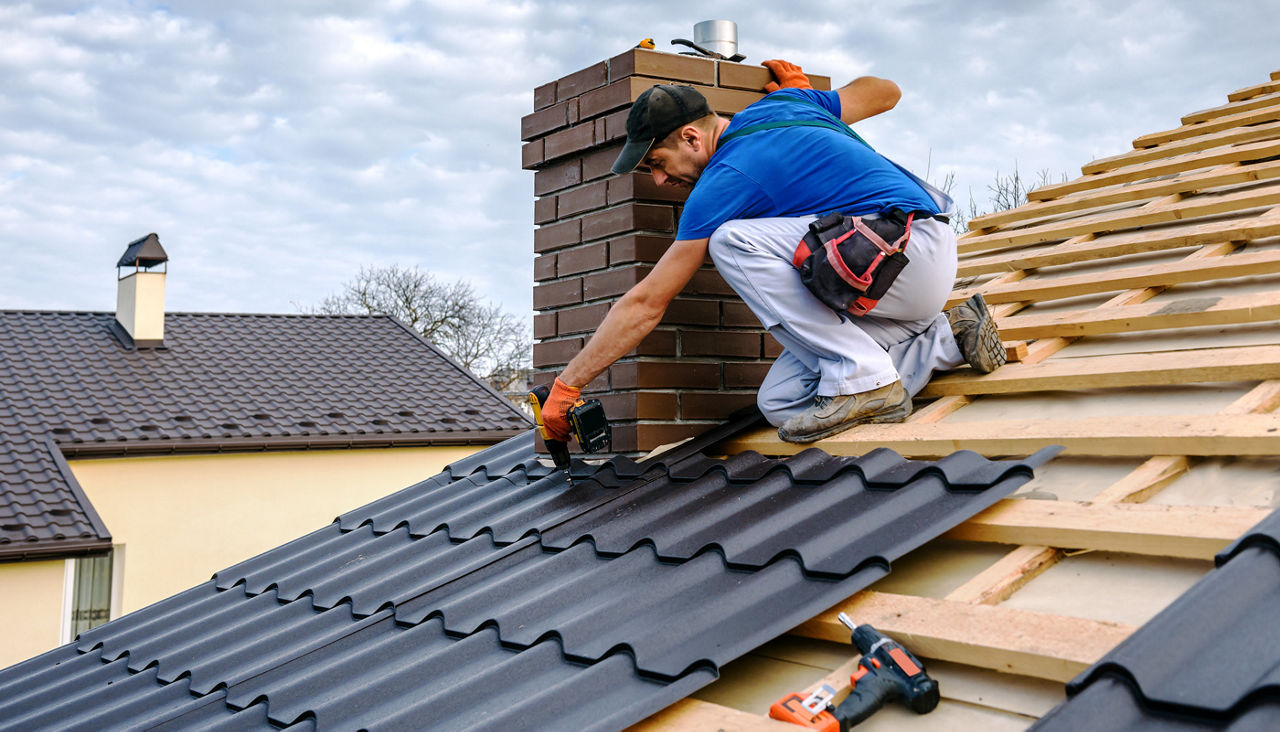 Professional roofer installing tiles around a chimney