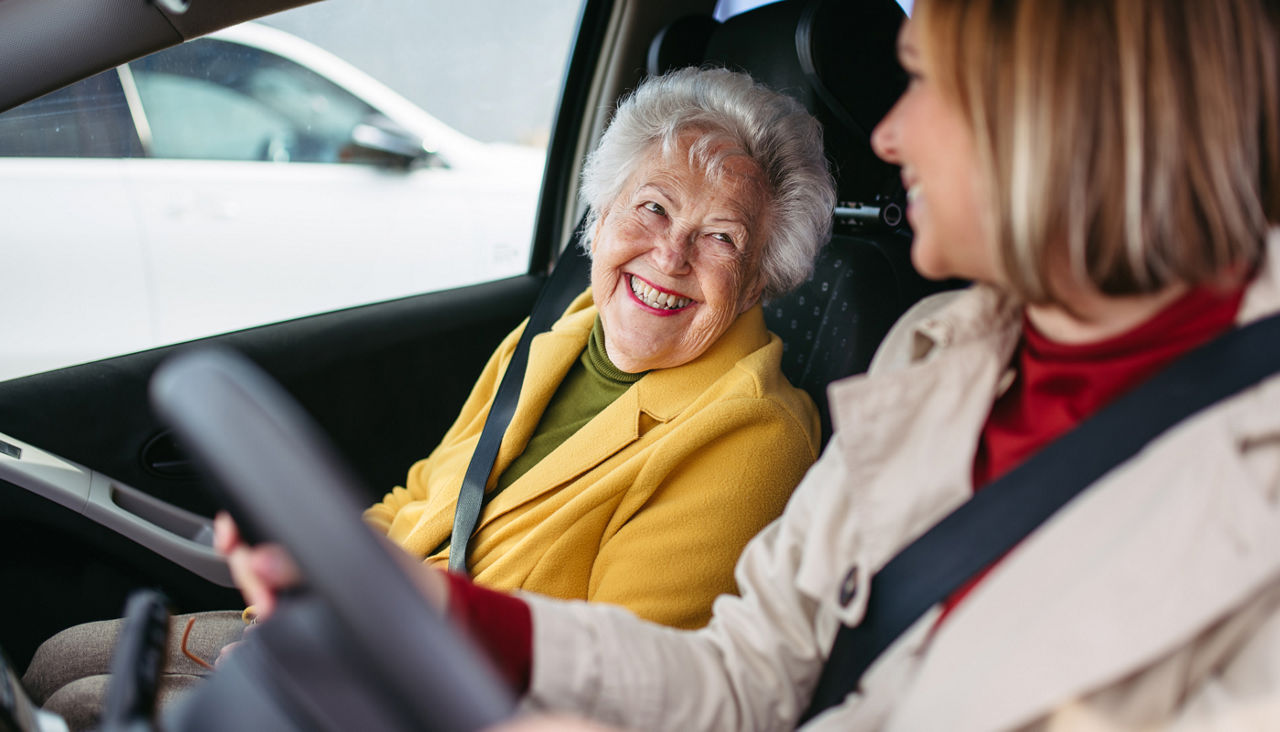 Granddaughter driving her elderly grandmother in the car