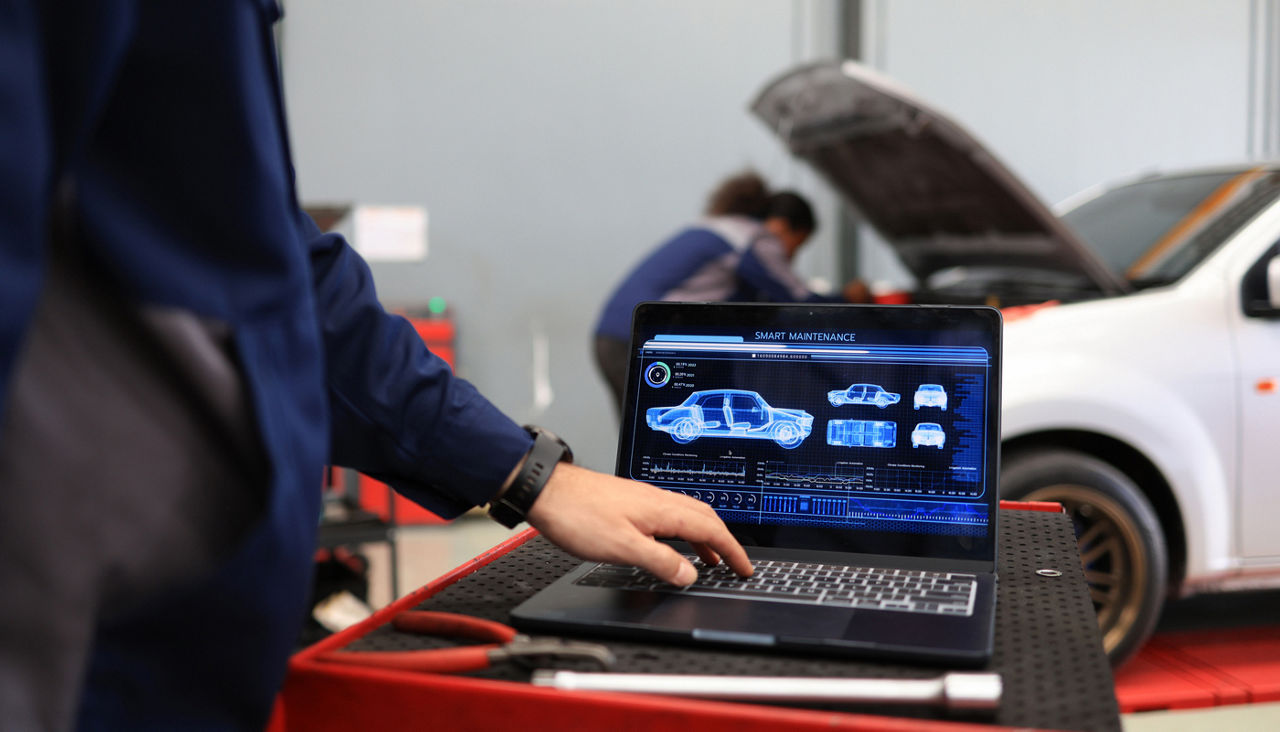 A mechanic using a computer application to assess a vehicle's issues.