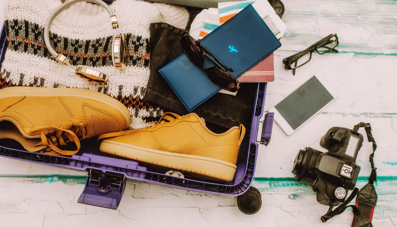 Open suitcase with winter travel items